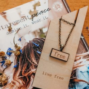 small wood necklace that reads free.