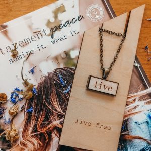 small wood necklace that reads live.