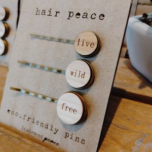three sustainable wooden bobby pins with the words live, wild and free