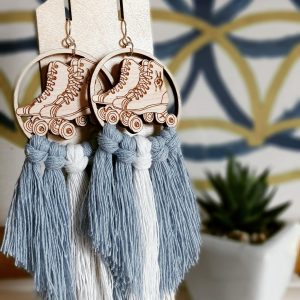 retro roller skate dangle earrings with blue and white fringe on a wooden display